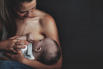 Wall Mural - Mom breastfeeding newborn baby at home. Woman nursing baby in cozy home. Care mother spends her time caring for newborn child. Concept of motherhood and happy family. Copy space