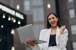 © MZaitsev - Happy excited successful businesswoman triumphing on city street.