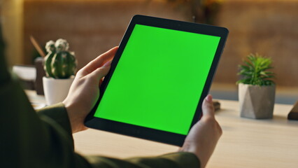 Wall Mural - manager watching chroma key tablet at desk close up. hands holding green screen.