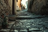 Fototapeta Uliczki - A picturesque view of a narrow cobblestone street in an old town. Perfect for travel websites and historical publications