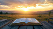 Open bible book on a wooden table at sunset with cross in front of it. Strong Christian faith