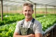 © masyastadnikova - Potrait of a vegetable grower working in a large industrial greenhouse growing vegetables and herbs. Farmer