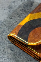 Handmade genuine leather products. Men's and women's wallet. Lying on a gray background. Top view of the object.