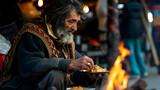 Fototapeta  - Homeless poor man eats on the street  in the park