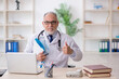 © Elnur - Old male doctor working in the clinic