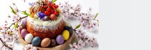 Homemade Traditionla Easter Kulich Cake With Chocolate Nests And Eggs, Blossoming Cherry Branches And Muscari Flowers. White Background. Banner Size