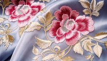 Close-up Of A Blue Fabric With Pink Flowers Embroidered On It The Flowers Have Gold Stems And Leaves