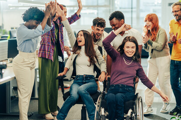 Wall Mural - Laughing female racing woman with disability in an office chair race