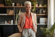 © Adriana - Smiling confident stylish mature middle aged woman standing at home office. Mature businesswoman, gray-haired lady executive business leader manager looking at camera with her ands in her pockets