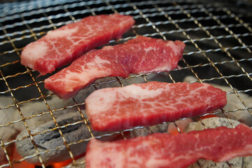 Raw beef is grilled on charcoal.