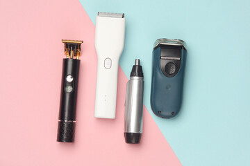 Trimmers and razors on a blue-pink background. Top view. Flat lay