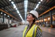 A proud smiling 40-year-old female boss wearing safety clothes in a modern warehouse or logistical facility