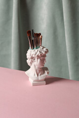 Wall Mural - David bust vase with makeup brushes against the background of curtain. Aesthetic beauty still life. Minimalism.