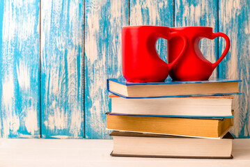 Wall Mural - two heart shaped mugs is on a stack of books
