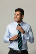 © Image Smith - Happy Indian business man adjusting his tie.