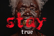A black old woman with gold teeth and the inscription stay true