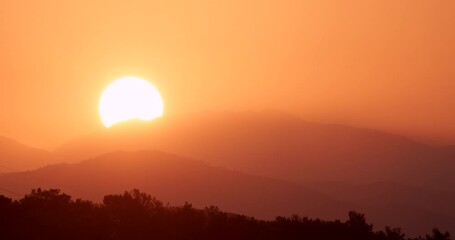 Wall Mural - Sun Sunrise From Behind Mountains Time-lapse. Amazing Bold Golden Sunrise Gradient Sky Background. Natural Bright Dramatic Sky. Warm Yellow And Orange Colors. Sun Above Mediterranean Coast Of Turkey.