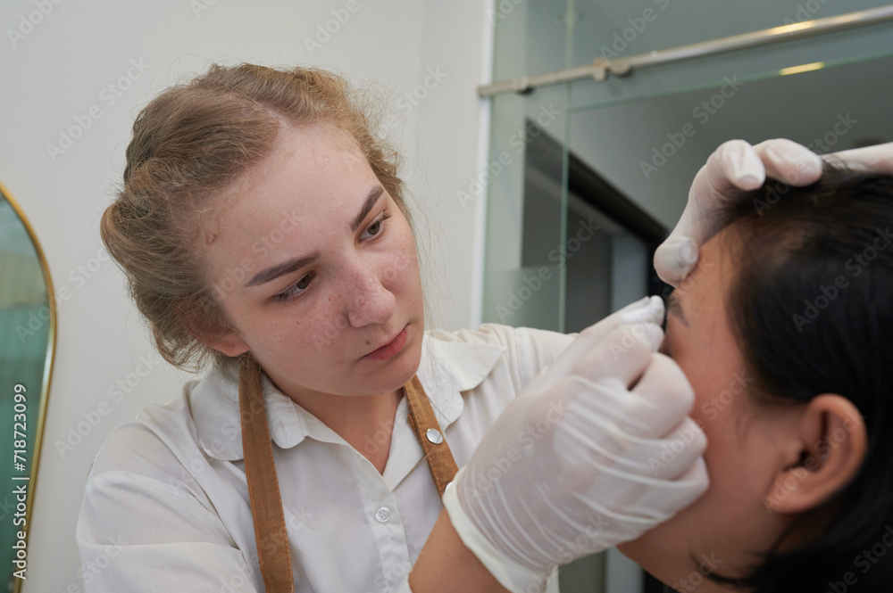 macro photography of the model's hairs the master combs the eyebrow hairs with a  brush after the procedure long-term styling and lamination