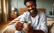 © Ruslan Gilmanshin - Happy positive handsome middle aged man in pajamas sitting on bed at home, holding mug, drinking coffee in the mornin and smiling