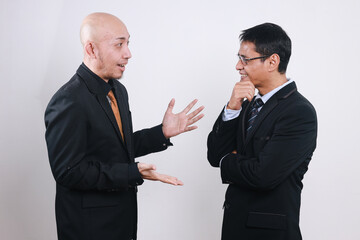 Two Asian businessmen having conversation together, talking with hand gesture.