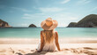 back view of woman sitting on tropical sandy beach sunbathing