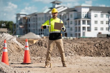 Wall Mural - Hispanic man construction worker in helmet at building. Construction building. Construction site manager. Worker in helmet on the new building. Builder with hardhat helmet on construction site.