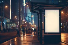 A Blank White Vertical Digital Billboard Poster On A City Street Bus Stop Sign At Night.
