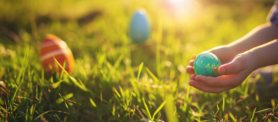 Wall Mural - Easter egg hunt. Little child hunting for colorful painted eggs in spring garden on Easter day. Traditional Easter festival outdoors. Focus on multicolor eggs. Sunlight in the spring. Happy Easter 