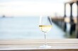 white wine glass with coastal ocean pier in the background