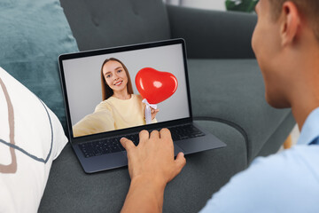 Poster - Long distance love. Man having video chat with his girlfriend via laptop at home, closeup