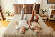 © dusanpetkovic1 - A senior couple is lying on a bed in bedroom at home and doing morning workouts.