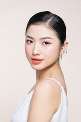 Wall Mural - Beautiful young Asian woman with clean fresh skin on beige background