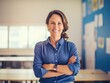 © Svetlana - smiling teacher standing in classroom with arms crossed.