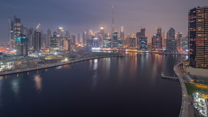 Wall Mural - Aerial view to Dubai Business Bay and Downtown with the various skyscrapers and towers day to night timelapse