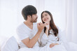 © SOMKID - Happy love Asian young man and woman staying together in bedroom, Valentine's Day, Concept of holiday and surprise.