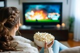 Fototapeta  - Cozy Woman eating popcorn and watching tv at home