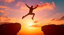 Silhouette Of Enthusiastic Man Jumping Between Two Cliffs. Success And Freedom Concept