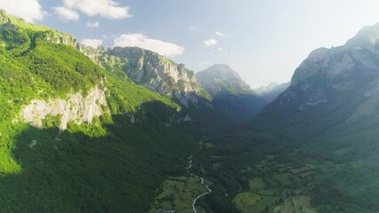 Wall Mural - Shooting from a drone of high mountains and a beautiful valley at sunset