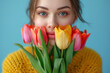 © Good Shot - Portrait of stylish young woman hiding her face behind bouquet of white tulips. The concept of spring, International Women's Day, March 8. Advertising perfume, flower shop