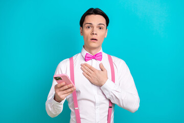 Wall Mural - Photo portrait of pretty young male touch chest frightened hold device wear trendy pink outfit isolated on cyan color background