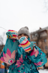 Wall Mural - Child girl playing in snow playground in winter, 5-6 years old kid