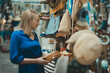 © M-Production - Woman choosing a bag at the evening bazaar.