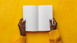 © Robert - Elegant hands of an African woman hold an open notebook with blank pages.