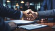 Close up of business people negotiating a contract and shaking hands in agreement during a meeting