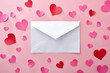 © Davizro Photography - White envelope with pink background with paper cutouts of hearts