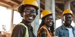 A group of African engineers smiling while collaborating on a construction project with coffee and tea, posing with a low angle shot.
