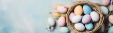 Colorful Easter Eggs In A Straw Basket. Pastel Colored Background.