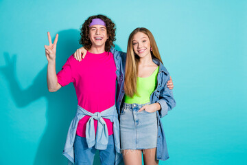 Wall Mural - Portrait of two best friends youngster curly hair guy and blonde lady show v sign victory symbol isolated on aquamarine color background