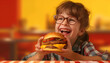 Happy young girl enjoying a burger