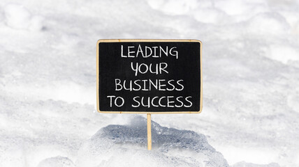 Wall Mural - Leading your business to success symbol. Concept words Leading your business to success on beautiful blackboard. Beautiful snow background. Leading your business to success concept. Copy space